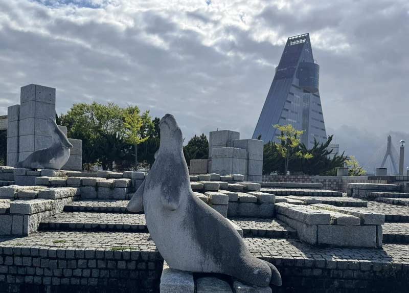 הטיילת עם פסלים וברקע המגדל המשולש