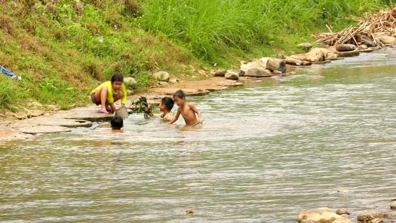 Vietnamese children taking a dip in the stream waters