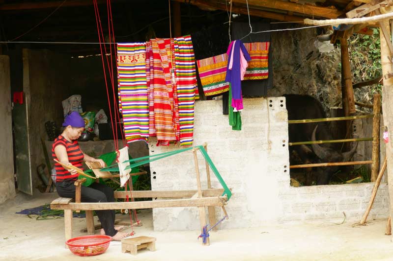 A village woman weaving on a loom
